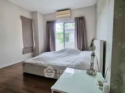 Spacious bedroom with large window and modern decor
