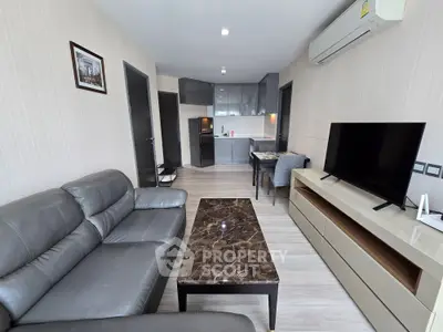 Modern living room with sleek furniture and open kitchen layout in a stylish apartment.