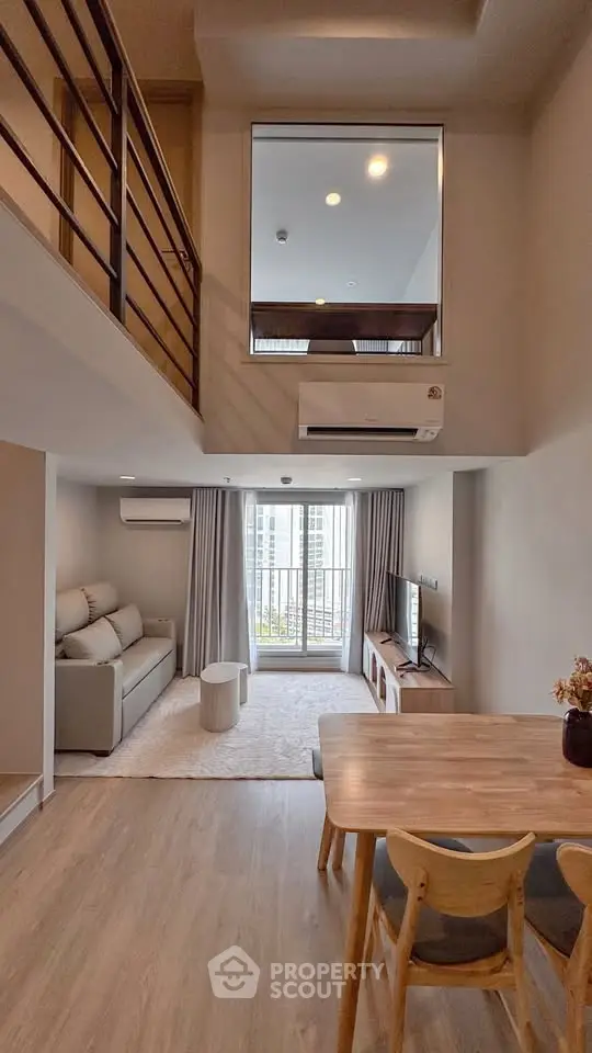 Modern loft-style living room with high ceiling and cozy decor