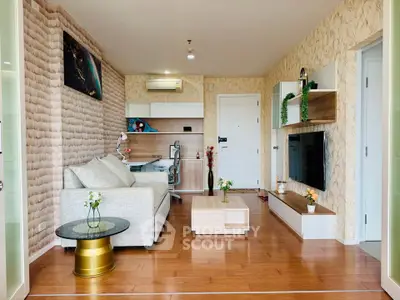 Modern living room with stylish decor, wooden flooring, and a cozy workspace corner.