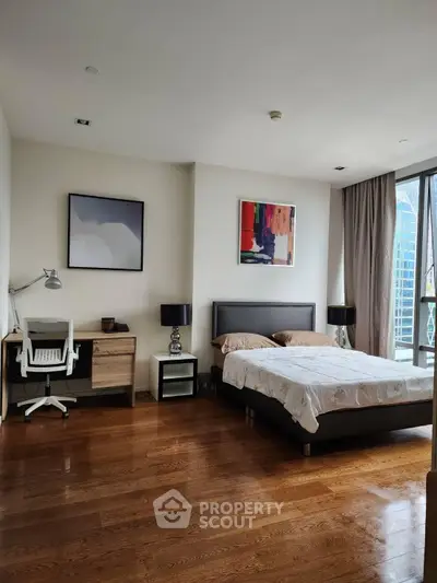 Spacious modern bedroom with wooden flooring and stylish decor