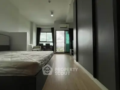 Spacious bedroom with modern design and balcony view, perfect for urban living.