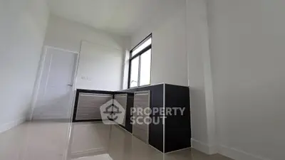 Modern minimalist kitchen with sleek cabinetry and large window
