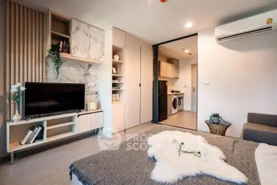 Modern living room with stylish decor and open layout, featuring a cozy sofa and sleek entertainment center.
