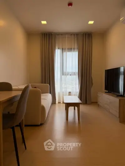 Modern living room with cozy sofa, TV, and dining area in a stylish apartment.