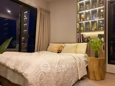 Cozy bedroom with city view, featuring a stylish bed and illuminated shelves for a modern touch.
