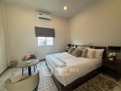 Spacious bedroom with modern decor and natural light, featuring a comfortable bed and stylish furnishings.