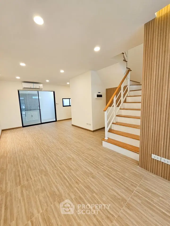 Spacious modern living room with wooden flooring and elegant staircase