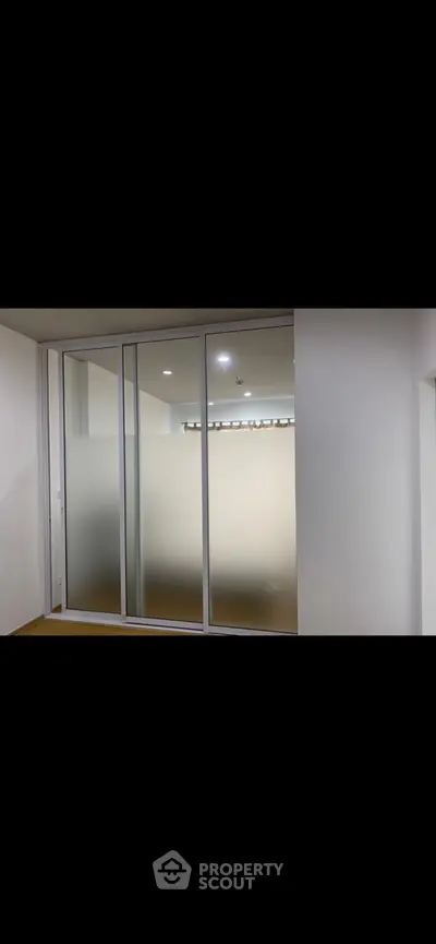 Modern interior with frosted glass sliding doors in a sleek apartment.