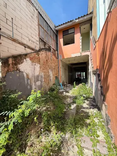 Explore potential with this fixer-upper property featuring an overgrown courtyard and unique architectural elements.