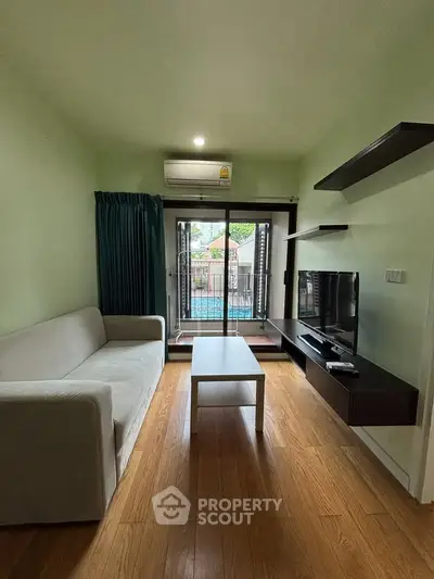 Cozy living room with modern decor and balcony view, perfect for relaxation.
