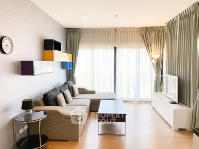 Spacious modern living room with stylish decor and large windows for natural light.