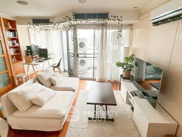 Spacious living room with modern decor and balcony view, featuring cozy seating and entertainment setup.