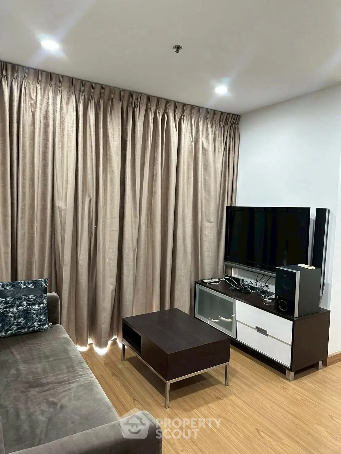 Cozy living room with modern furniture and entertainment setup, ideal for relaxation.