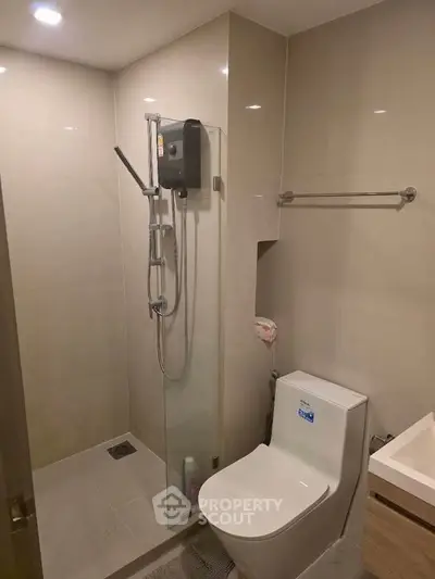 Modern bathroom with sleek shower and toilet in a contemporary apartment.