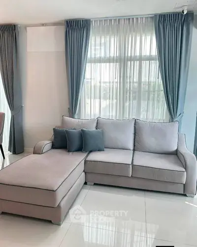 Modern living room with stylish gray sofa and elegant blue curtains