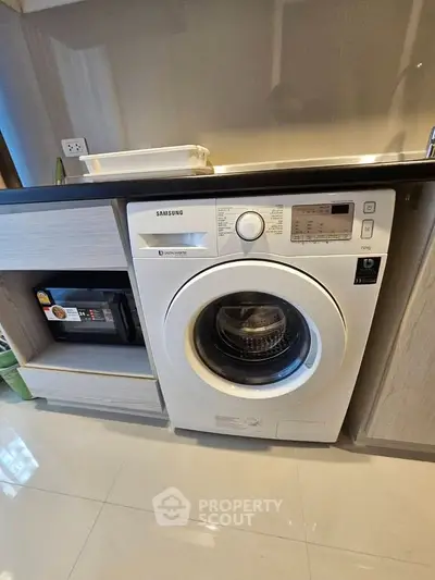 Modern kitchen with built-in Samsung washing machine and sleek cabinetry.