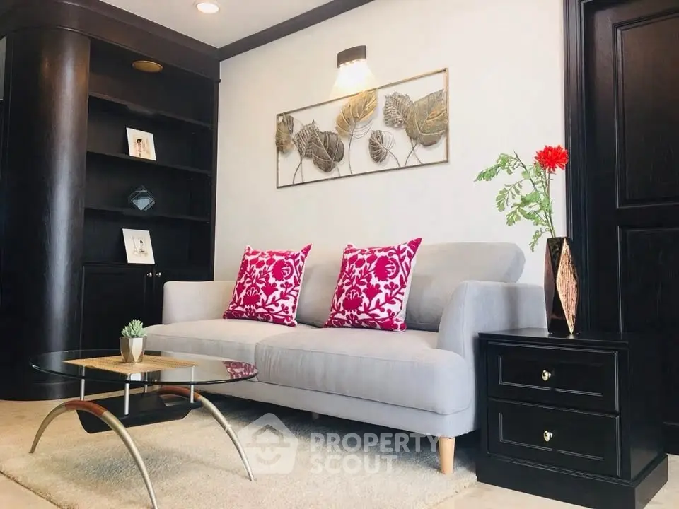 Stylish living room with modern decor, featuring a cozy gray sofa and vibrant red cushions.