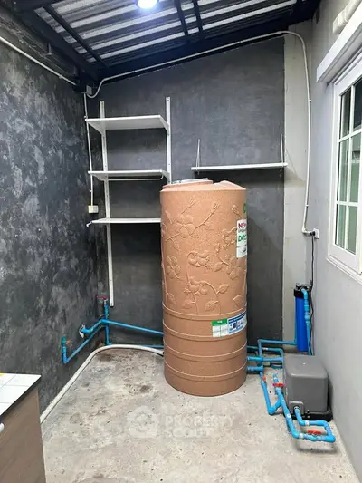 Utility room with water tank and plumbing in modern home