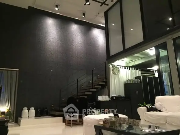 Luxurious modern living room with high ceilings and stylish staircase