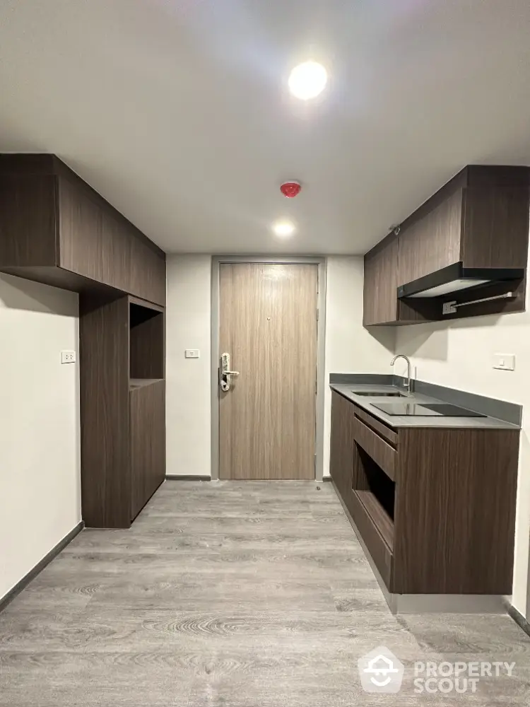 Modern minimalist kitchen with sleek cabinetry and wood flooring