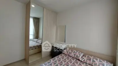 Modern bedroom with stylish bedding and mirrored wardrobe in a cozy apartment.