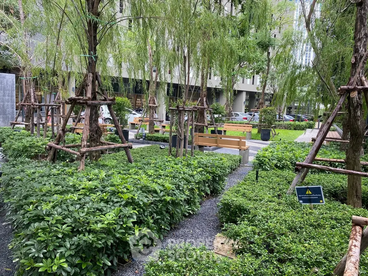 Lush green garden with benches in a modern residential complex