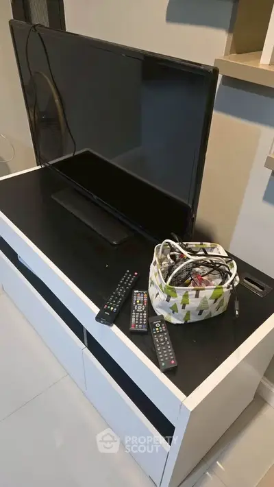 Modern living room with sleek TV stand and organized remote controls, perfect for entertainment setup.
