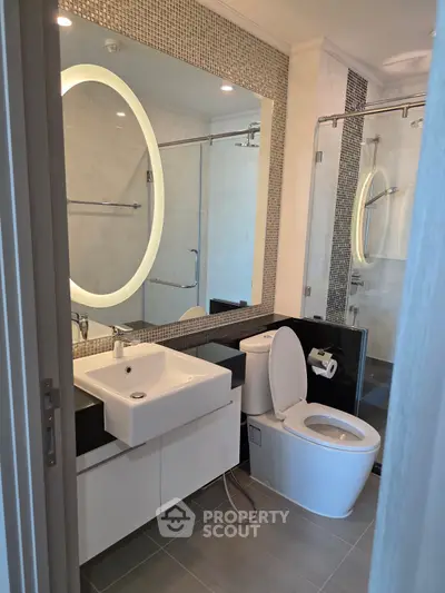 Modern bathroom with illuminated mirror and sleek fixtures in a contemporary apartment.