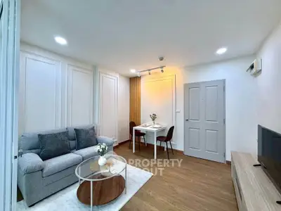 Modern living room with cozy sofa, stylish decor, and dining area in open layout apartment.