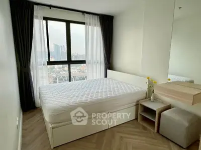 Modern bedroom with large window offering stunning city views, featuring a cozy bed and minimalist decor.