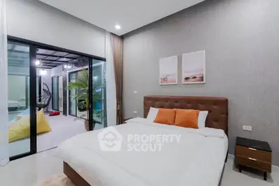 Modern bedroom with cozy decor and sliding glass doors leading to a stylish balcony.