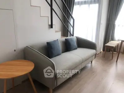 Modern living room with stylish sofa and natural light, perfect for relaxation and comfort.