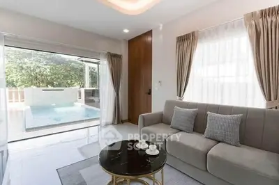 Luxurious living room with pool view, elegant sofa, and modern decor in a bright, airy space.