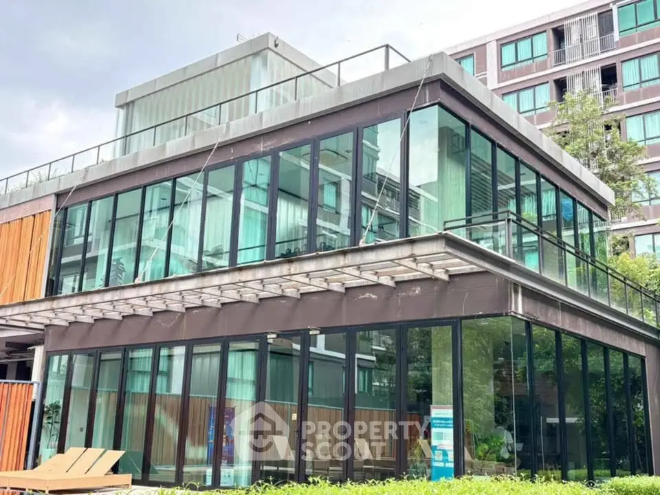 Modern glass building with sleek design and lush greenery, perfect for contemporary living.