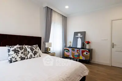Stylish bedroom with modern decor and artistic touches, featuring a comfortable bed and elegant furnishings.