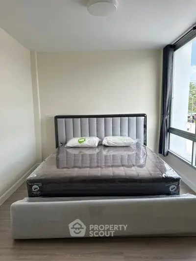 Modern bedroom with stylish bed and large window offering natural light