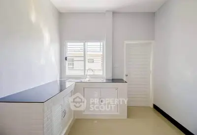 Modern kitchen with sleek countertops and ample natural light, perfect for culinary enthusiasts.