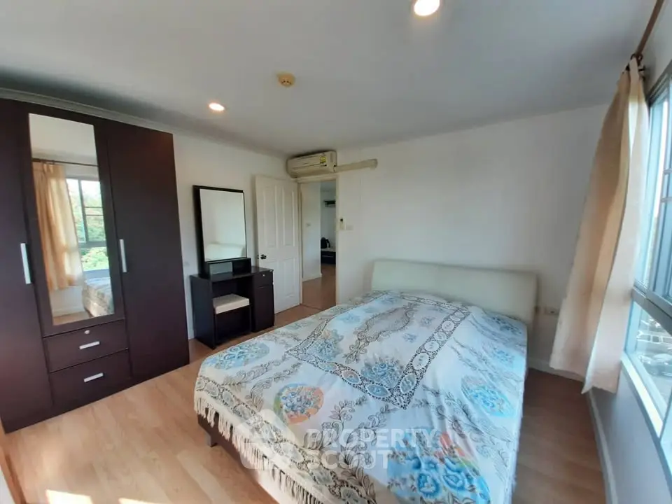 Spacious bedroom with large window and modern furniture