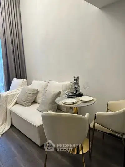 Elegant living room with cozy sofa and stylish dining setup.