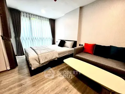 Modern bedroom with cozy bed and stylish sofa in a well-lit space.