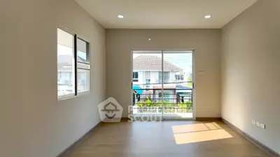 Bright empty room with large windows and balcony access in modern home