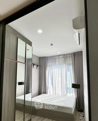 Modern bedroom with large window and sleek design, featuring a comfortable bed and stylish decor.