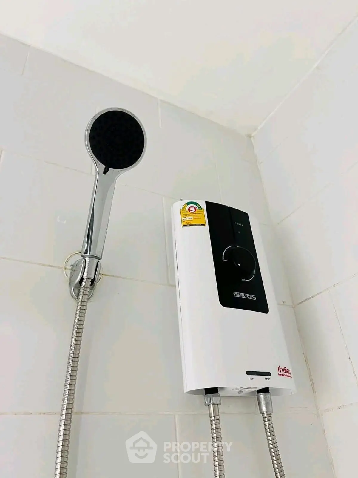 Modern bathroom shower with sleek water heater and chrome fixtures.