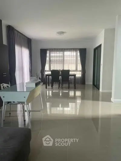 Spacious modern living room with dining area and large windows for natural light.
