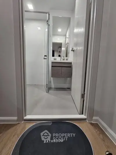 Modern bathroom with sleek design and minimalist fixtures, featuring a stylish vanity and mirror.