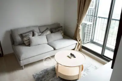 Cozy living room with modern sofa and balcony view, perfect for relaxation.