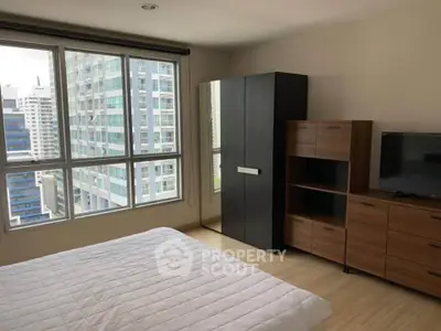 Modern bedroom with large windows offering stunning city views in a high-rise apartment.