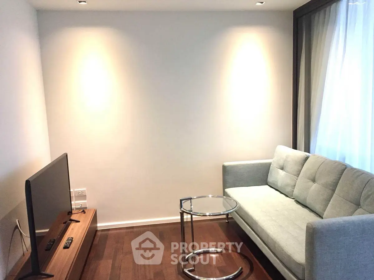 Modern living room with sleek sofa and flat-screen TV, perfect for relaxation.