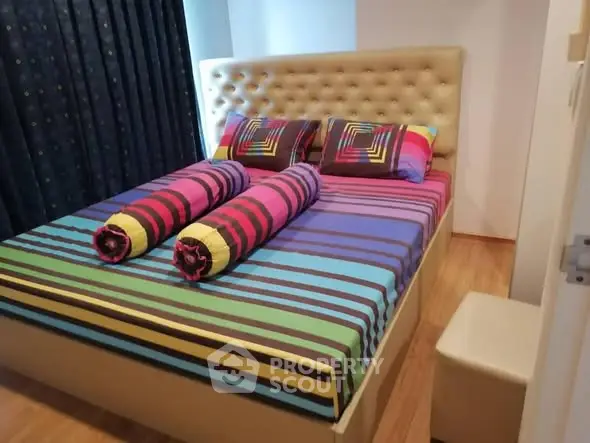Cozy bedroom with colorful striped bedding and tufted headboard
